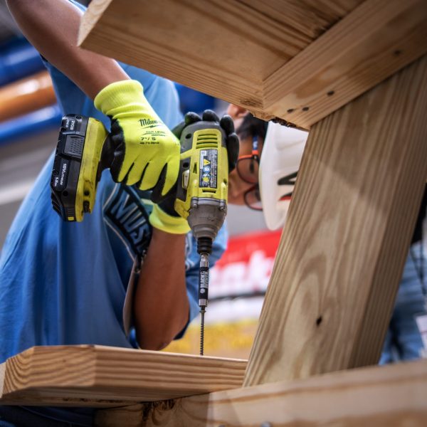 Teenager drilling wooden table at NAWIC 2023 camp