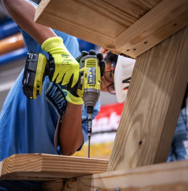 Teenager drilling wooden table at NAWIC 2023 camp